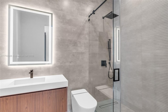 bathroom featuring toilet, a shower stall, vanity, and tile walls