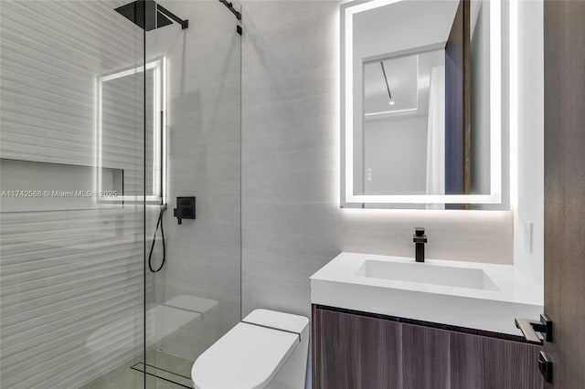 bathroom with toilet, vanity, tile walls, and a shower stall