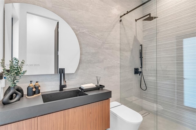 bathroom with toilet, a stall shower, vanity, and tile walls