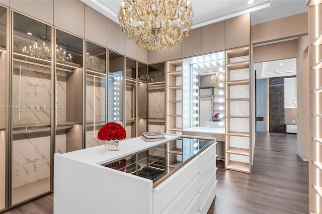 walk in closet featuring dark wood finished floors and a notable chandelier