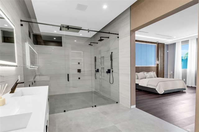 bathroom featuring connected bathroom, a shower stall, and vanity