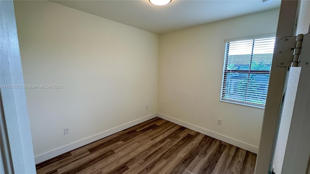 empty room featuring dark wood-style floors and baseboards