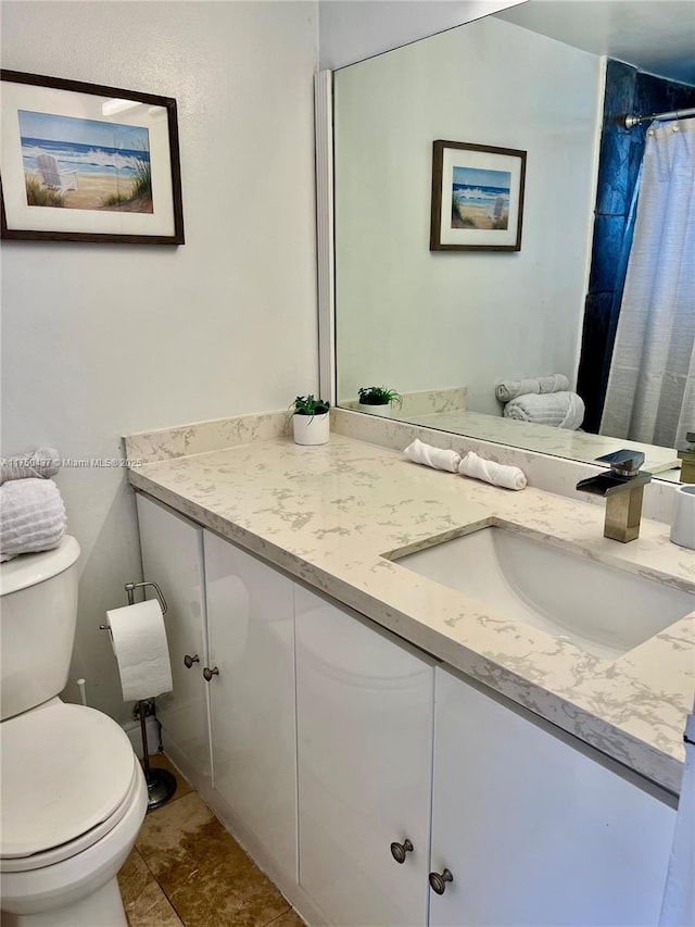 bathroom featuring toilet, a shower with shower curtain, and vanity