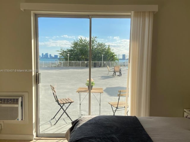 bedroom featuring access to outside, a city view, and multiple windows