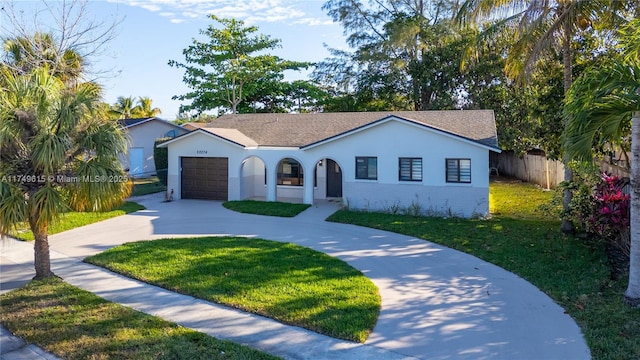 view of front of property featuring a front lawn, fence, concrete driveway, a garage, and brick siding