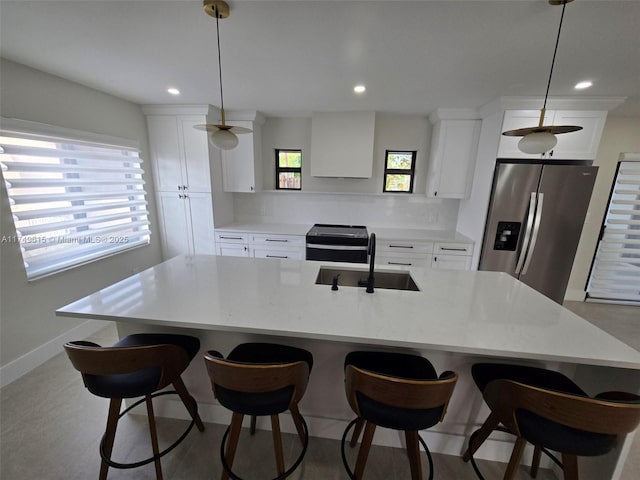 kitchen with white cabinetry, a breakfast bar area, appliances with stainless steel finishes, and a sink