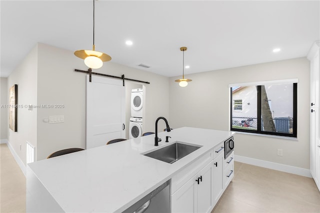 22274 SW 61st Ave, Boca Raton, FL 33428 - kitchen featuring stacked washing machine and dryer, a barn door, light countertops, white cabinetry, and decorative light fixtures