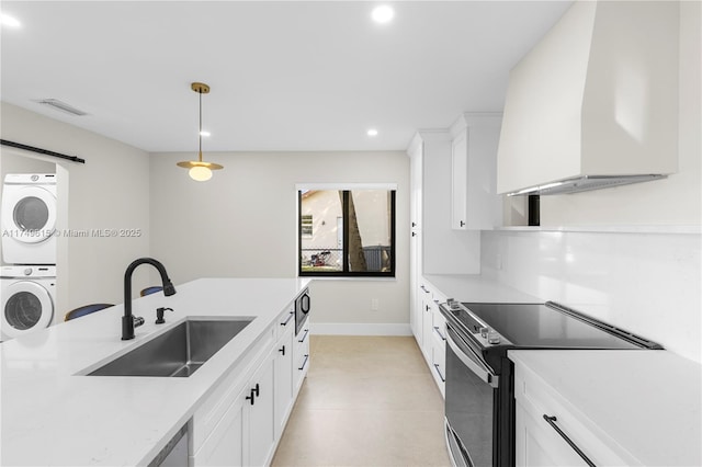 22274 SW 61st Ave, Boca Raton, FL 33428 - kitchen with estacked washer and dryer, electric range, premium range hood, white cabinetry, and light countertops