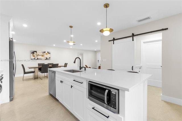 22274 SW 61st Ave, Boca Raton, FL 33428 - kitchen with appliances with stainless steel finishes, a barn door, light countertops, light tile patterned flooring, and white cabinets