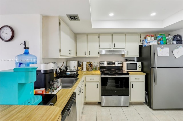 kitchen featuring light countertops, visible vents, appliances with stainless steel finishes, a sink, and under cabinet range hood