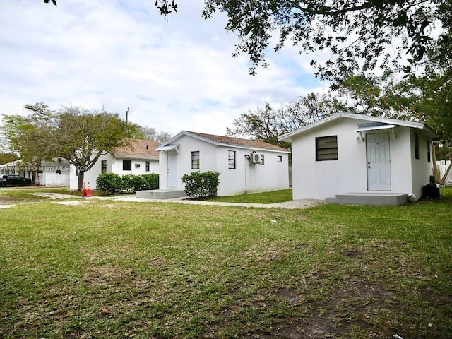 view of front facade with a front yard and stucco siding