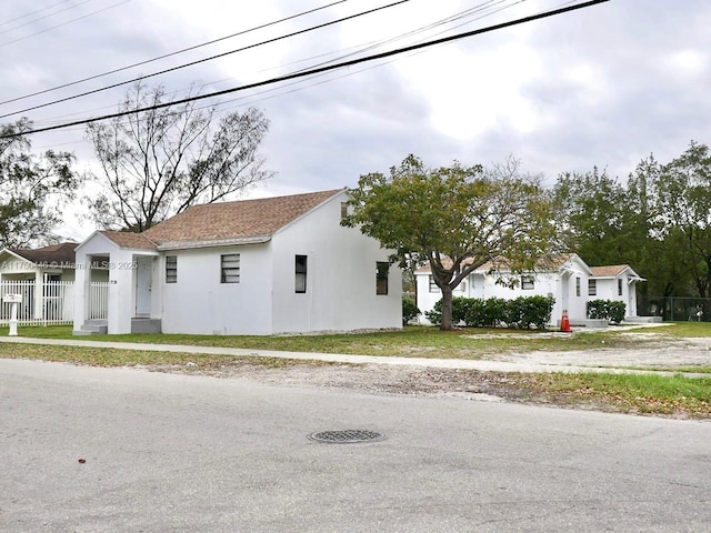 view of front of home featuring fence and stucco siding