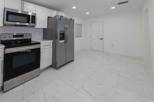 kitchen featuring marble finish floor, appliances with stainless steel finishes, light countertops, and visible vents