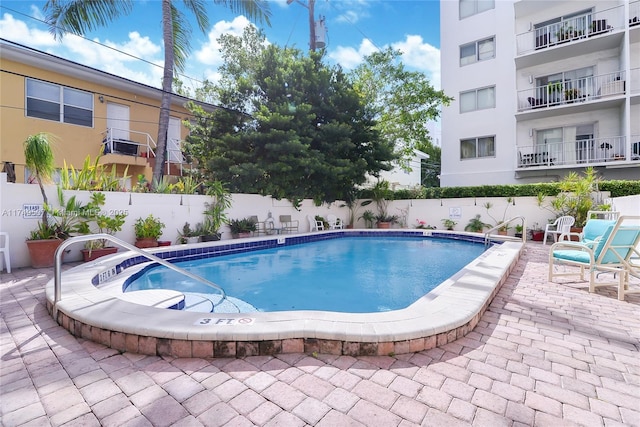 community pool featuring a patio and a fenced backyard