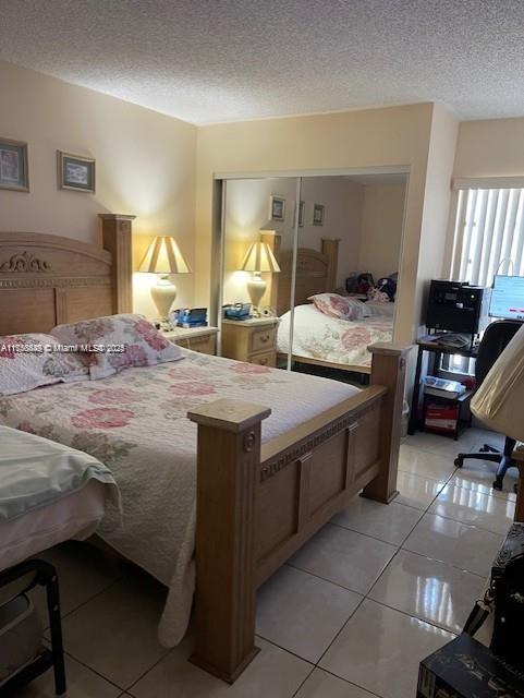 1350 SW 122nd Ave Unit 317, Miami, FL 33184 - bedroom featuring a textured ceiling, a closet, and light tile patterned flooring
