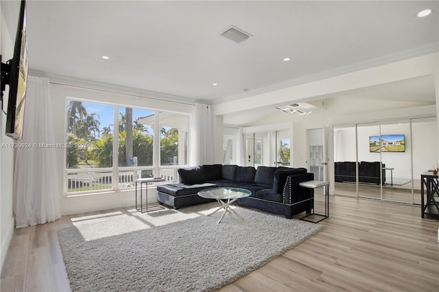 living area with lofted ceiling, recessed lighting, visible vents, and light wood-style floors