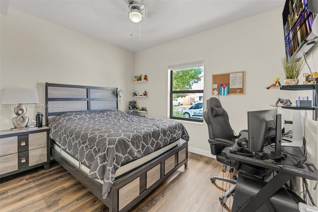 bedroom with ceiling fan, wood finished floors, and baseboards