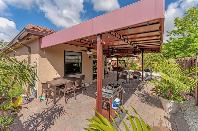 view of patio / terrace featuring ceiling fan and fence