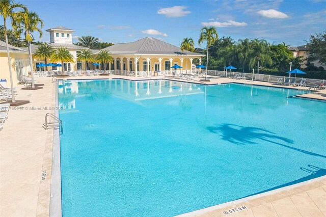 pool with a patio area and fence