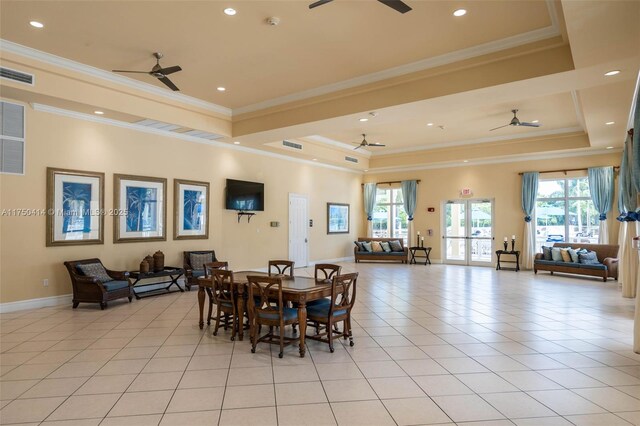 dining area with a tray ceiling, light tile patterned flooring, ceiling fan, and visible vents