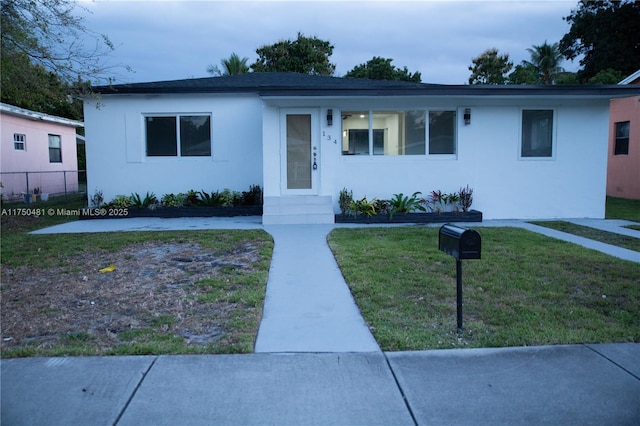 view of front of home featuring a front yard and stucco siding