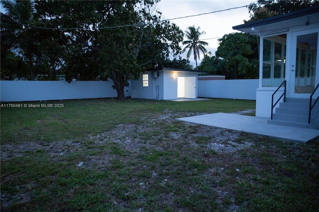 view of yard featuring entry steps, a patio area, a fenced backyard, and an outdoor structure