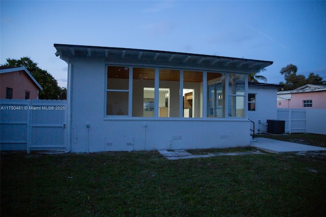 exterior space featuring crawl space, fence, a front lawn, and central AC unit