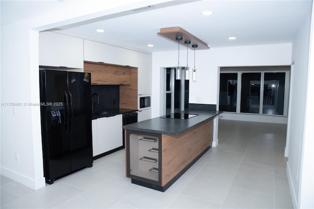 kitchen featuring light tile patterned floors, dark countertops, decorative light fixtures, black appliances, and white cabinetry