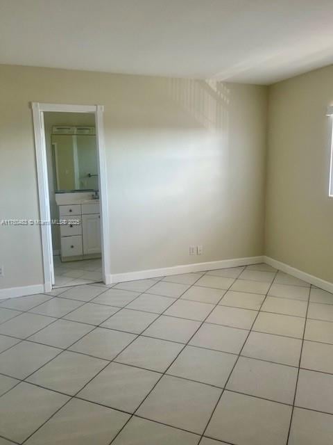5050 Bayview Dr Unit 17, Fort Lauderdale, FL 33308 - unfurnished bedroom with ensuite bath, baseboards, and light tile patterned flooring