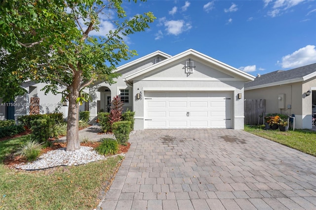 ranch-style house featuring a garage, decorative driveway, and stucco siding