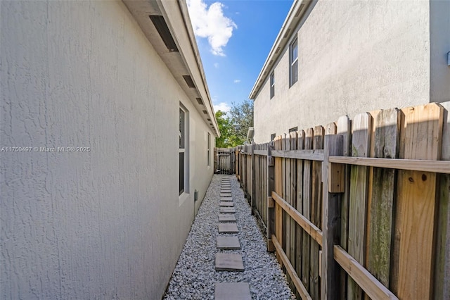 view of side of property featuring fence and stucco siding