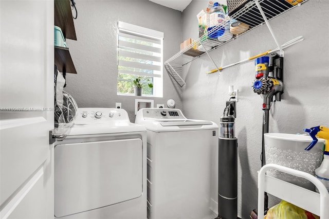 laundry room with a textured wall, laundry area, and independent washer and dryer