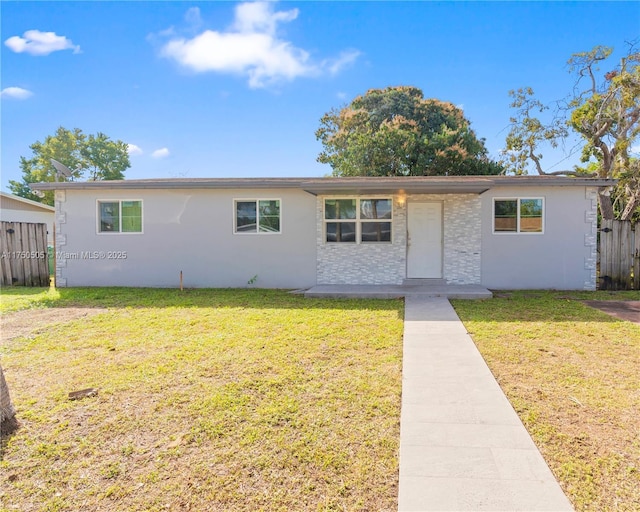 ranch-style home with fence, a front lawn, and stucco siding