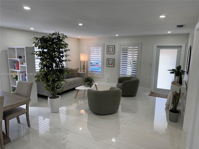 living room featuring baseboards, visible vents, and recessed lighting