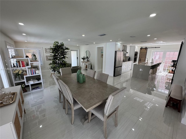 dining room with recessed lighting, visible vents, and a barn door