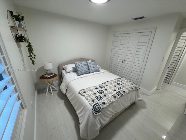 bedroom featuring baseboards, visible vents, and a closet