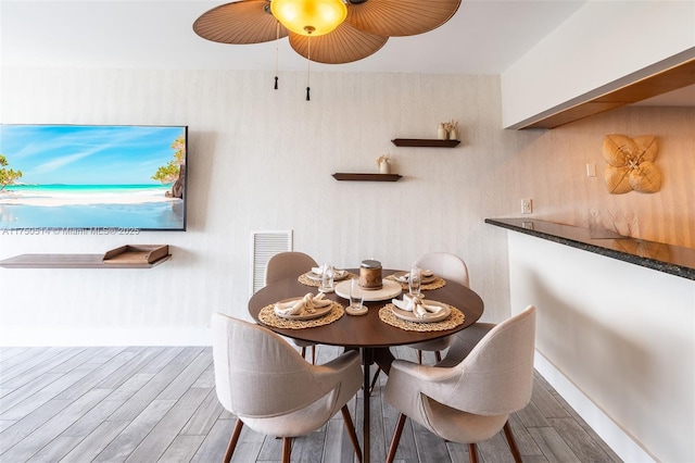 dining area featuring baseboards, visible vents, and wood finished floors