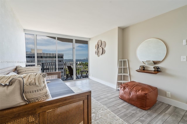 interior space featuring wood finish floors, baseboards, a city view, and expansive windows