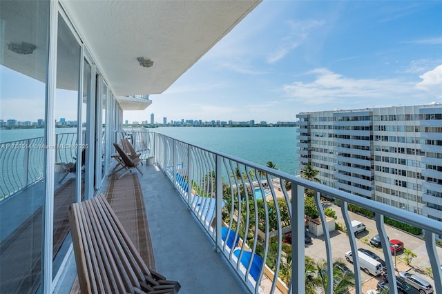 balcony featuring a water view and a city view