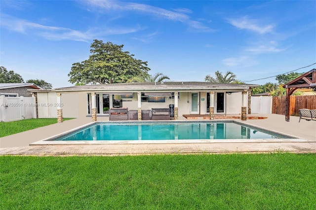 rear view of house featuring a lawn, a patio area, fence, and a fenced in pool