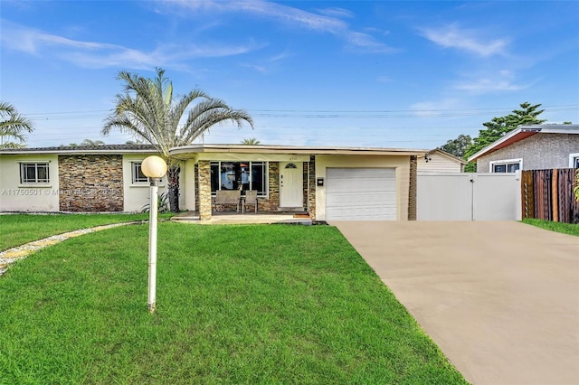 ranch-style home with a front yard, stone siding, driveway, and an attached garage