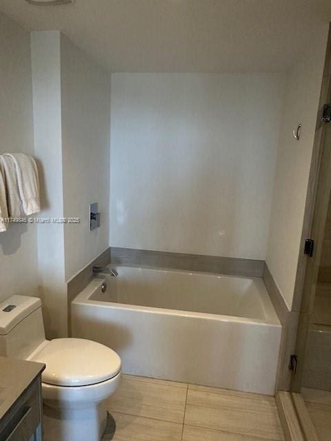 bathroom with a bath, vanity, and toilet