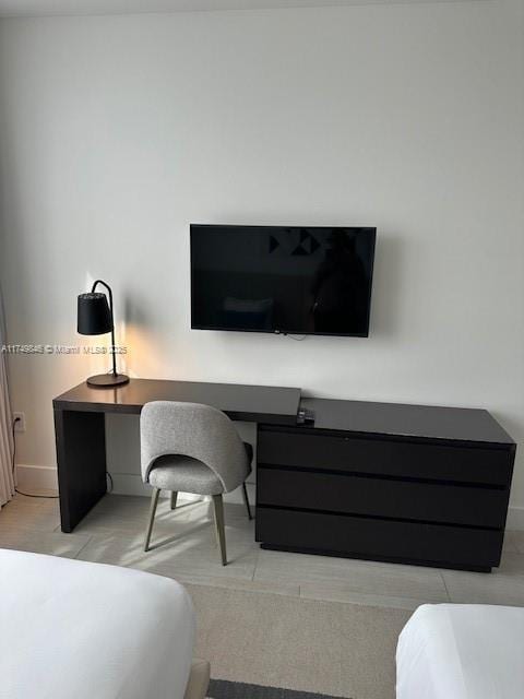 bedroom featuring baseboards and built in desk