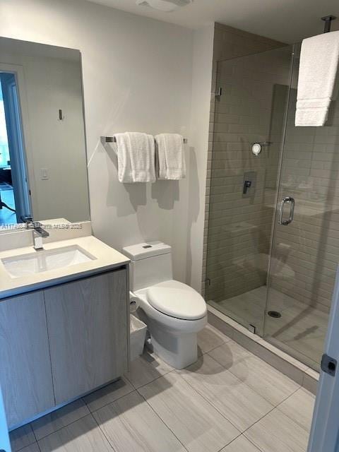 full bathroom featuring a shower stall, vanity, and toilet