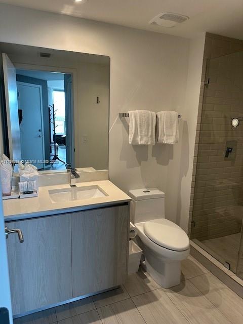 bathroom featuring a stall shower, visible vents, vanity, and toilet