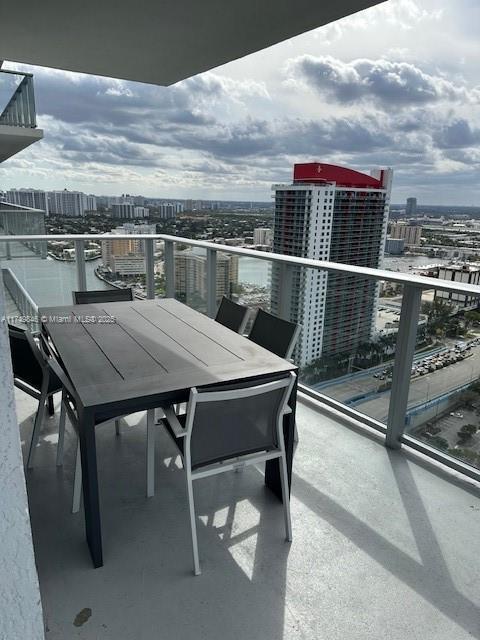 balcony featuring outdoor dining area and a city view