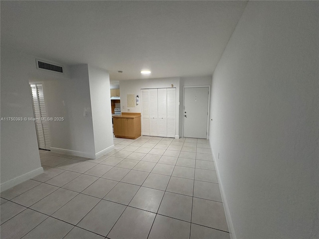 empty room with visible vents, baseboards, and light tile patterned floors