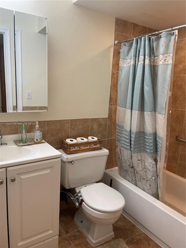 full bathroom with tile walls, tile patterned floors, vanity, toilet, and shower / tub combo with curtain