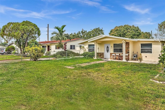 ranch-style house with fence, a front lawn, and stucco siding