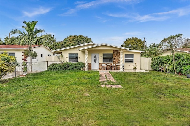 ranch-style house featuring a front yard, fence private yard, and stucco siding